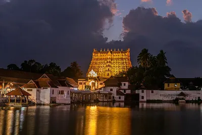 Padmanabhaswamy Temple gopuram lit at dusk above the Padma Theertham tank